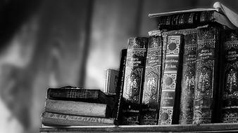 monochrome photo of antique books on a shelf in a store