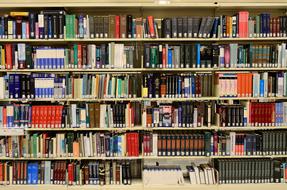 multi-colored books on shelves in the library