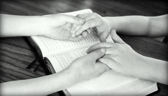 holding hands on the bible