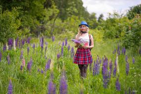 photo of a girl in a blue hat on a lupine field