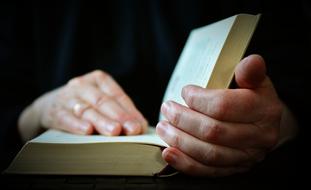 hands holding an open book