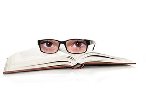 human eyes in glasses on open Book