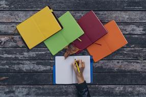 female hand with pen at blank notebook