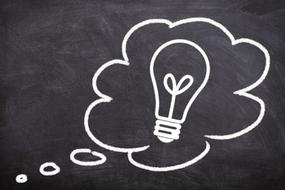 drawn thought bubble and a light bulb on a school blackboard