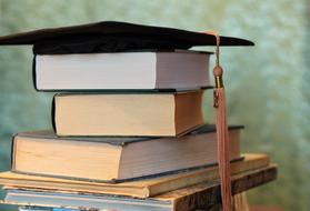 Books and Hat Magister close-up on blurred background