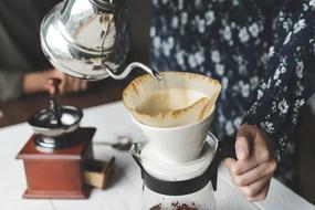 woman preparing Coffee by vintage equipment