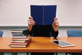 student reads a textbook at a school desk