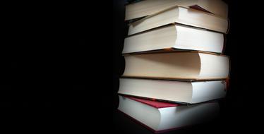 stack of literary books on a black background