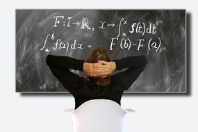 student looks at formulas on blackboard