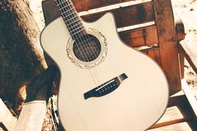 guitar on a wooden chair in the street