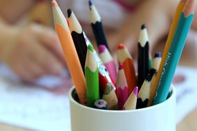 multi-colored pencils stand in a white glass