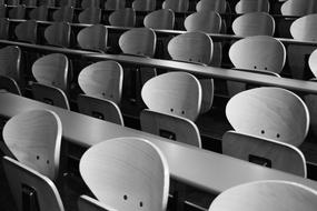 black and white photo of desks and chairs in the lecture room