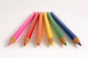 six colored pencils on a white background