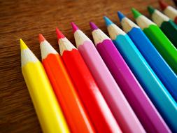 multicolored pencils on a wooden table
