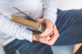 girl with old book close-up on blurred background