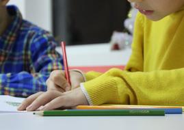 boy in yellow sweater with pencil