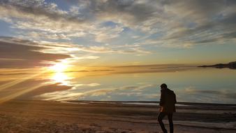 person Walking on beach of great salt lake at Sunset, usa, utah