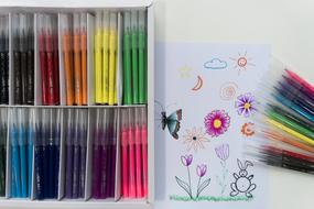 set of felt-tip pens and drawing on the table