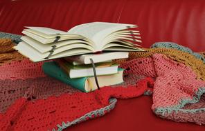 stack of books on a knitted blanket