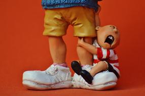 figurine of a crying child on a parent's leg