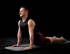 happy young man doing yoga exercise at darkness