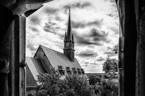 black and white photo of a church from the window of an abandoned building