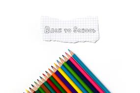 back to school writing on piece of paper and colored pencils