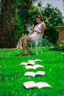 student with books on the lawn