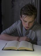 boy reads a textbook at the table