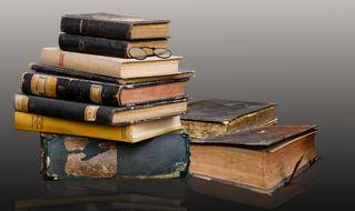 stack of old weathered books and glasses