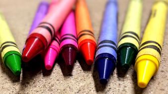 multi-colored wax crayons in the sand
