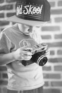 black and white photo of a child with a camera