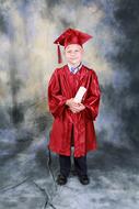 photo of a graduate with a diploma in red uniform