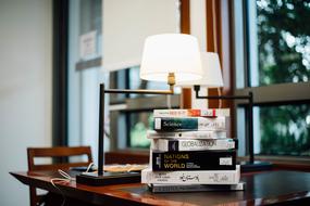 Colorful books on the table near the lamp