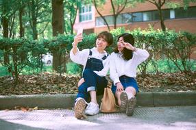 two cute asian girls taking selfie in University Campus