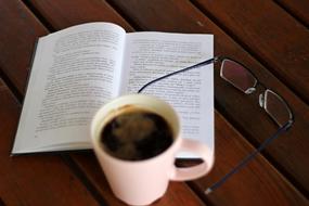 A cup of coffee near the Book and Glasses