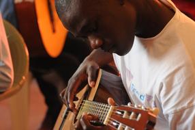 young african boy plays guitar