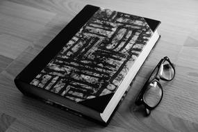 black and white picture of a notebook with glasses