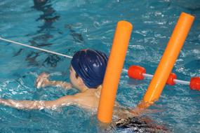 child learns to swim in the pool