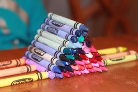 pyramid of pencils on a table close-up on a blurred background