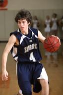 young basketball player with the ball runs in the hall