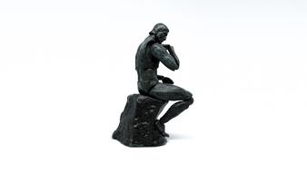 sculpture of a man on a stone on white