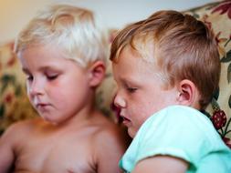 two brothers are reading a book