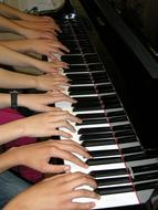 many hands on the piano keys
