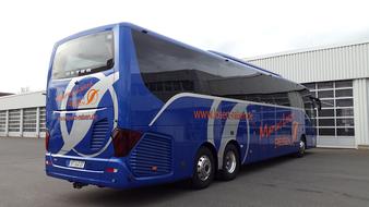 Blue Bus parked in front of garage