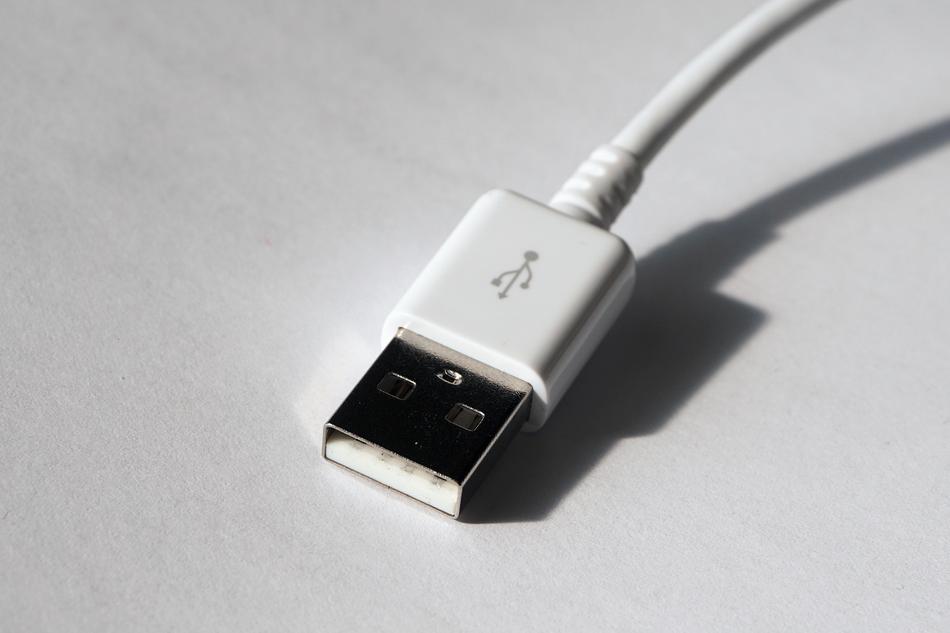Close-up of the white USB cable, with the wire, with shadow, in light