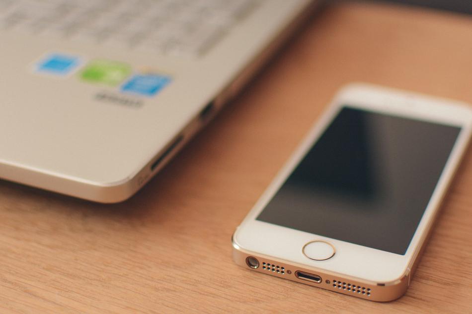 smartphone and laptop on table in blurred background