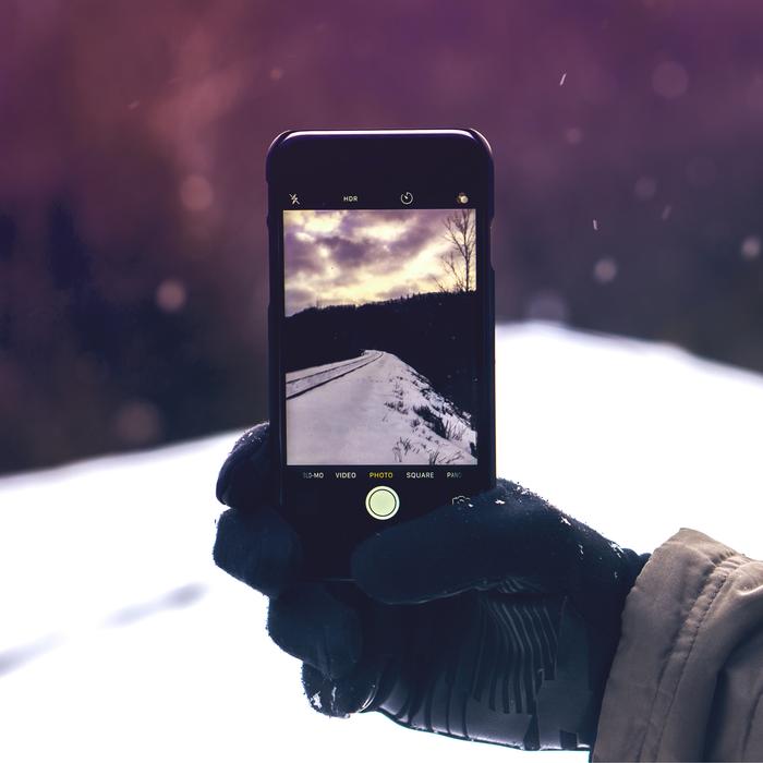 photo of a winter road on a smartphone screen