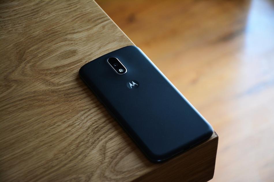 black mobile phone with camera on the edge of the table