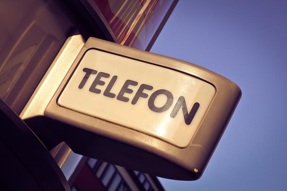 'Telephone' sign on the shield in light, outdoors